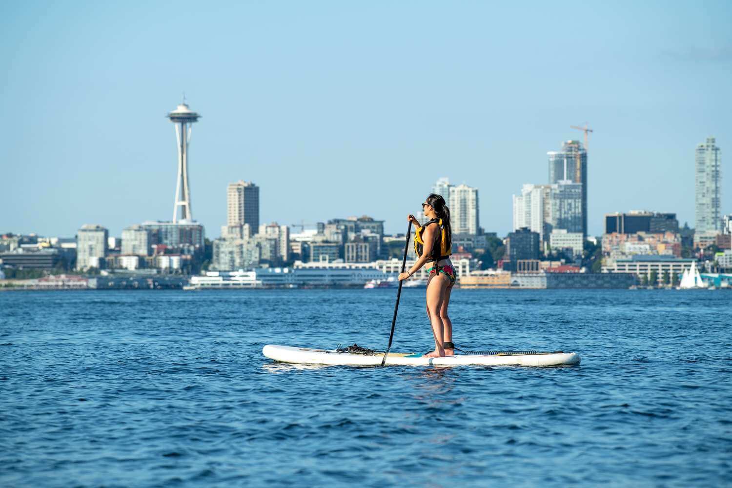 Woman on a stand-up paddleboard with the Seattle skyline in the background