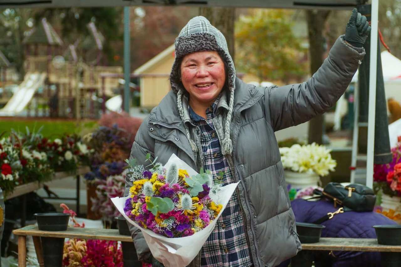A person holds a bouquet of flowers at the Vancouver Farmers Market