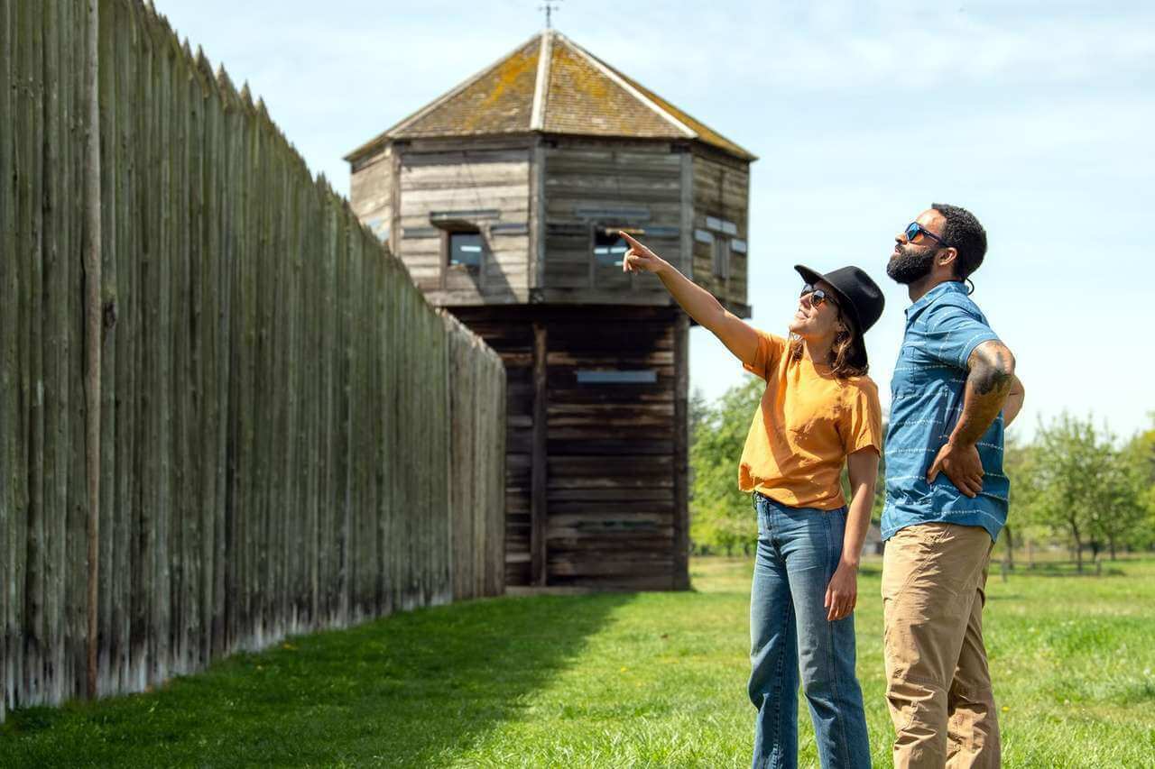 A man and woman look at the walls of Fort Vancouver