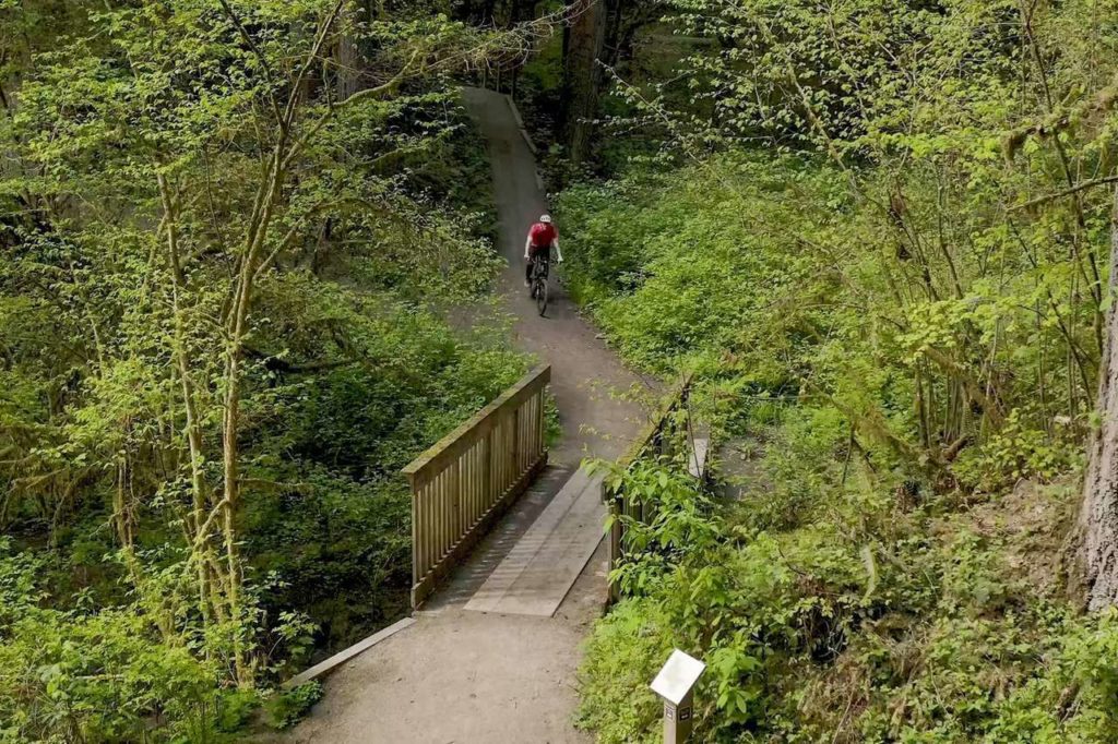 A person rides a bike along a trail at Whipple Creek