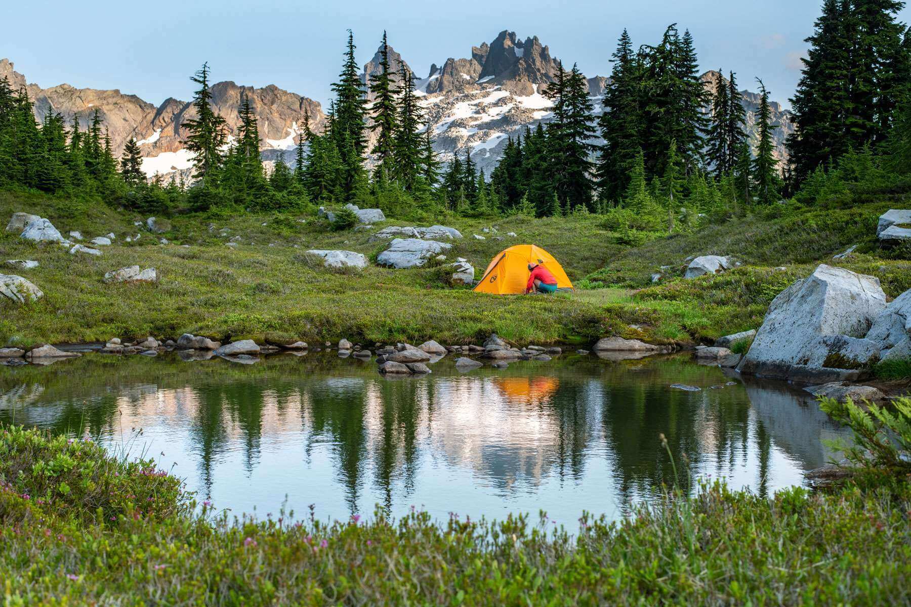 Hiking Trails In Washington - Yellow tent next to a lake with mountains in the background