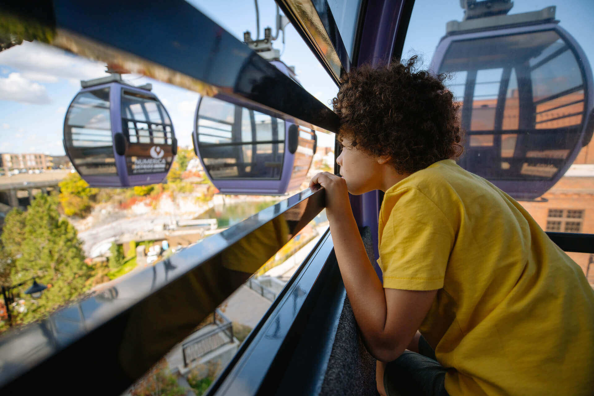 A young boy looks out of the skyride gondola in Spokane. 