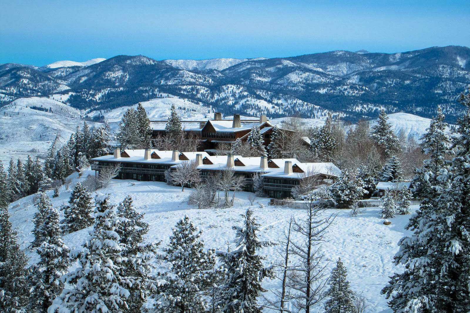 Sun Mountain Lodge covered in snow with foothills in the background - a cozy winter destination in Washington