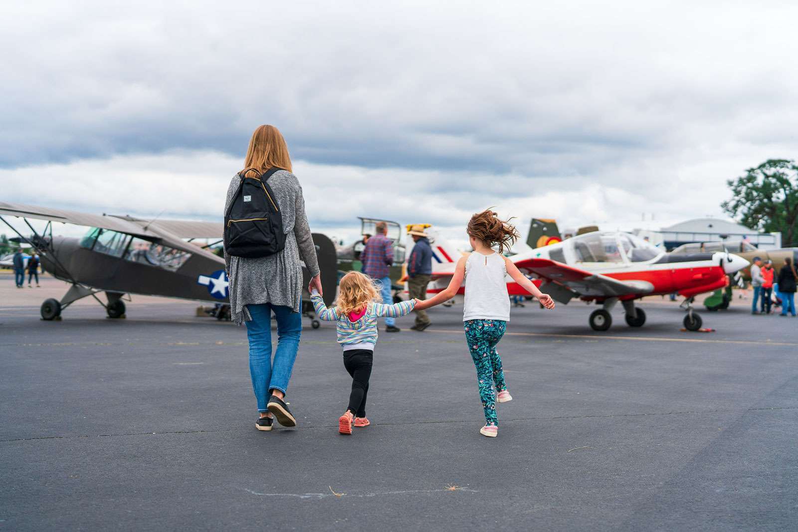 A woman and two young girls view airplanes at the Olympic Airshow in Tumwater, Washington