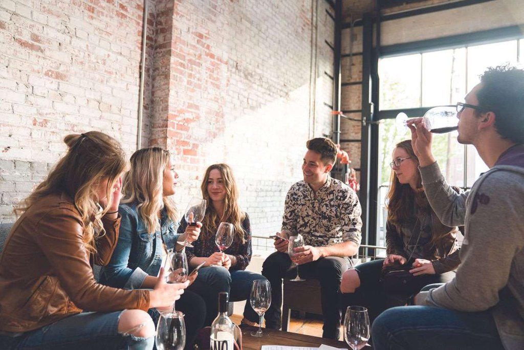 Group of men and women sipping wine at an indoor tasting room in Walla Walla