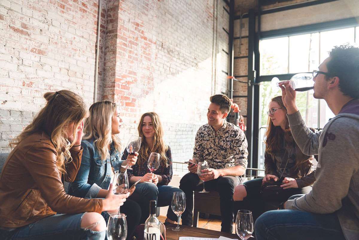 A group of men and women sip wine at an indoor tasting room in Walla Walla