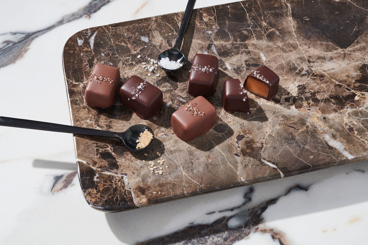 Sea salt caramels by Fran's Chocolates are displayed on a marble slab.  