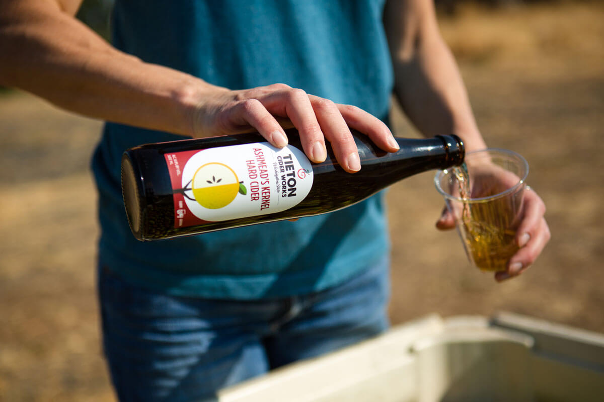 A man pours hard cider into a glass at Tieton Cider Works
