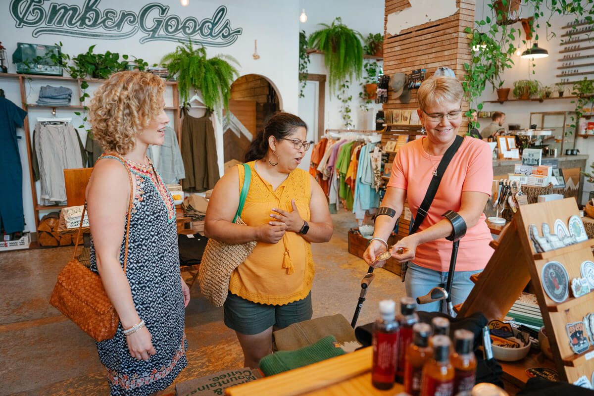 Three women look at jewelry at Ember Goods in Olympia.