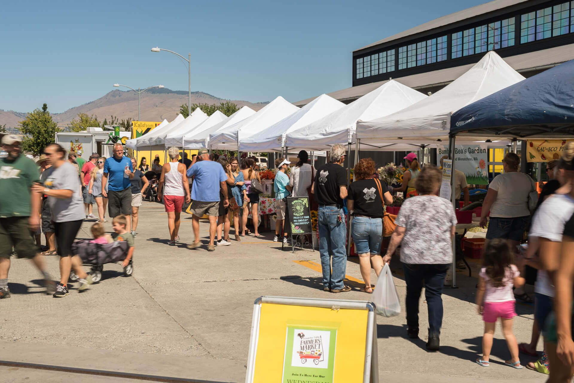 Shoppers browse stalls at the outdoor Wenatchee Valley Farmers Market. 