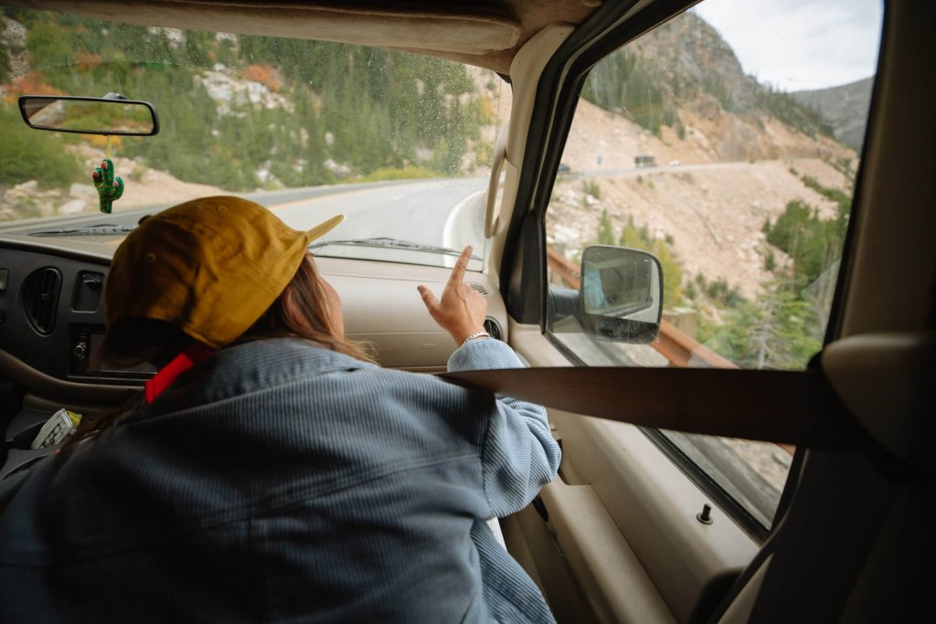 A woman points out the window while driving to North Cascades National Park.