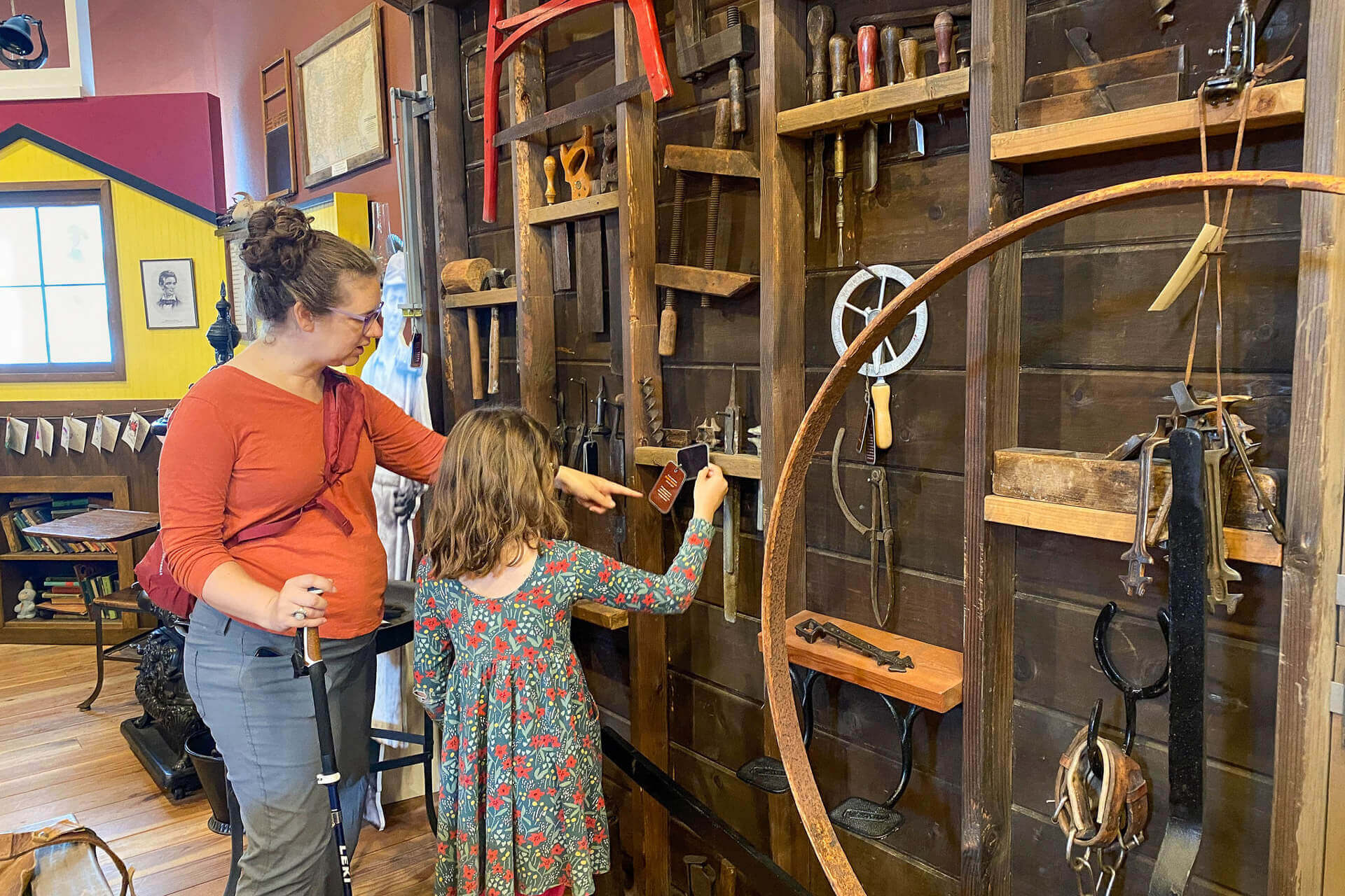 A mother and daughter look at an exhibit at the Raymond Carriage Museum