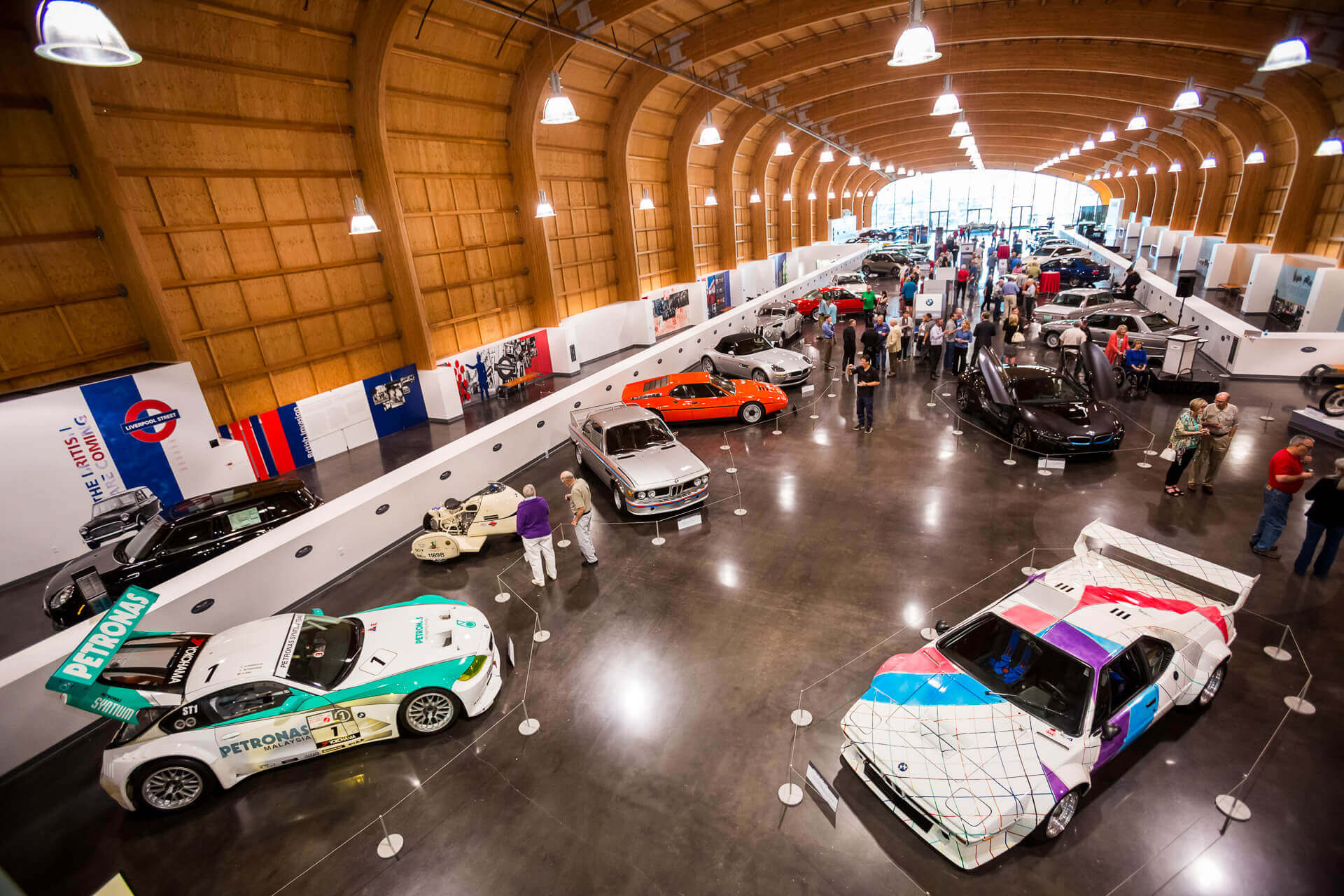 An overview of the interior of Lemay - America's Car Museum shows visitors viewing cars from different years