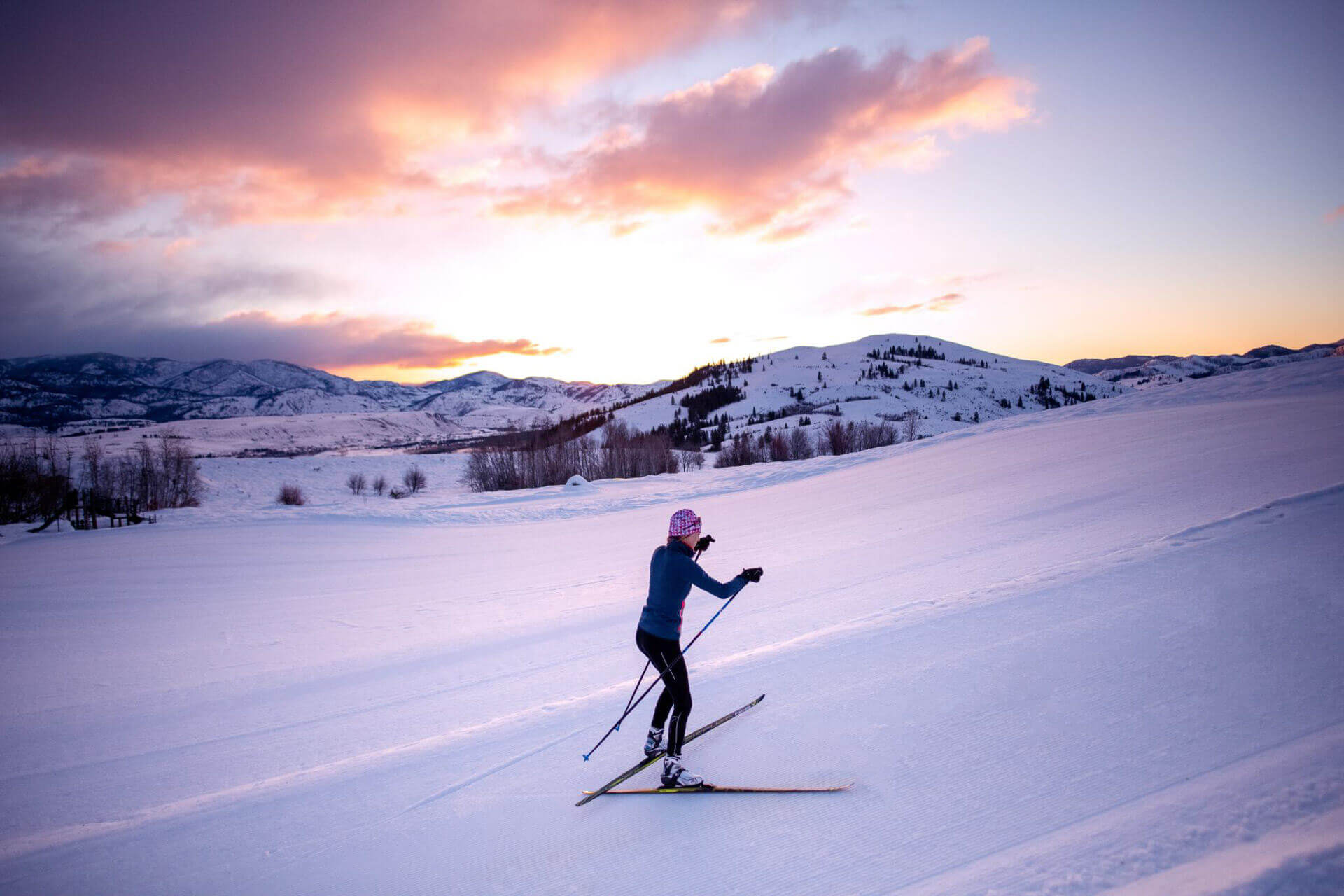 A woman enjoys cross-country skiiing at sunset in central Washington