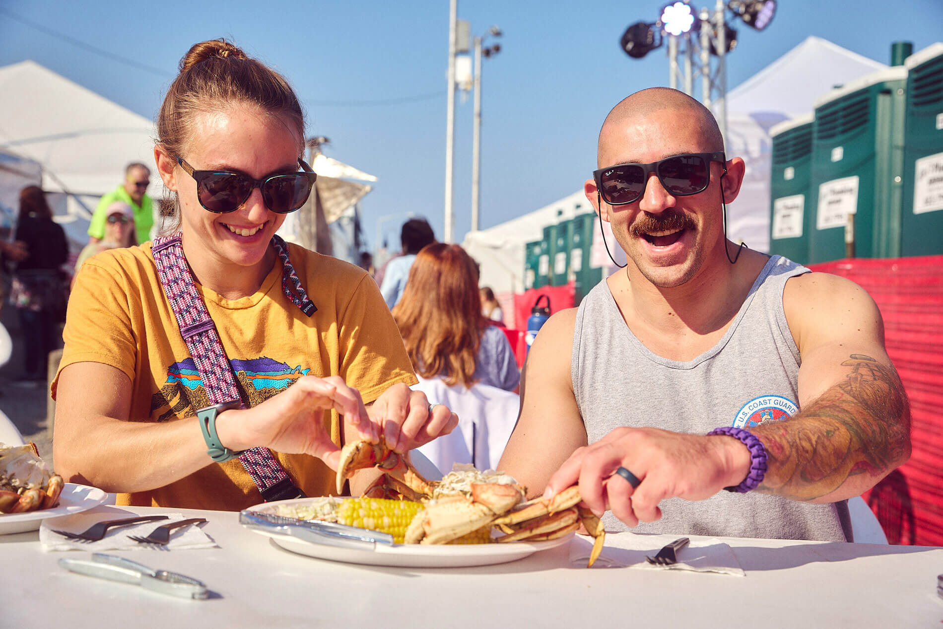A man and woman sit at a table and eat fresh crab at a seafood festival in Washington