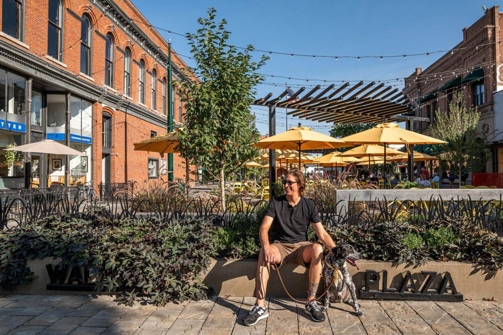 A man sits with his dog outside a courtyard eating area in Walla Walla
