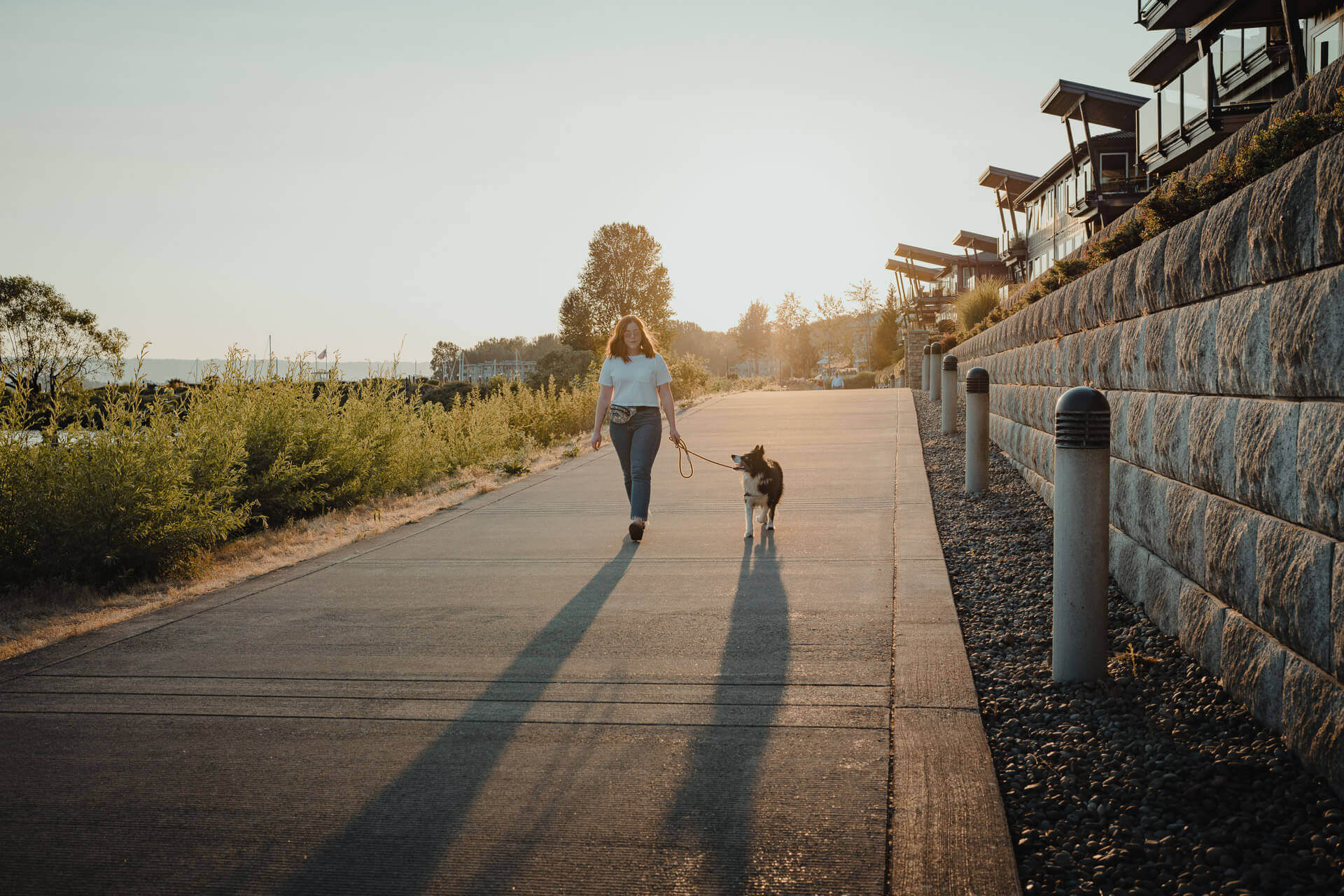A woman walks a dog on a leash along the Waterfront Renaissance Trail in Vancouver Washington