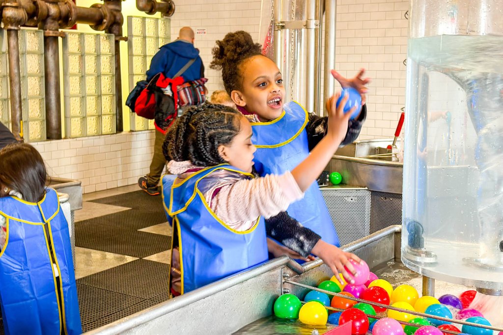 Two young girls play with colorful ball at a water table at Everett's Imagine Children's Museum. One of the top Kid-Friendly Museums in Washington