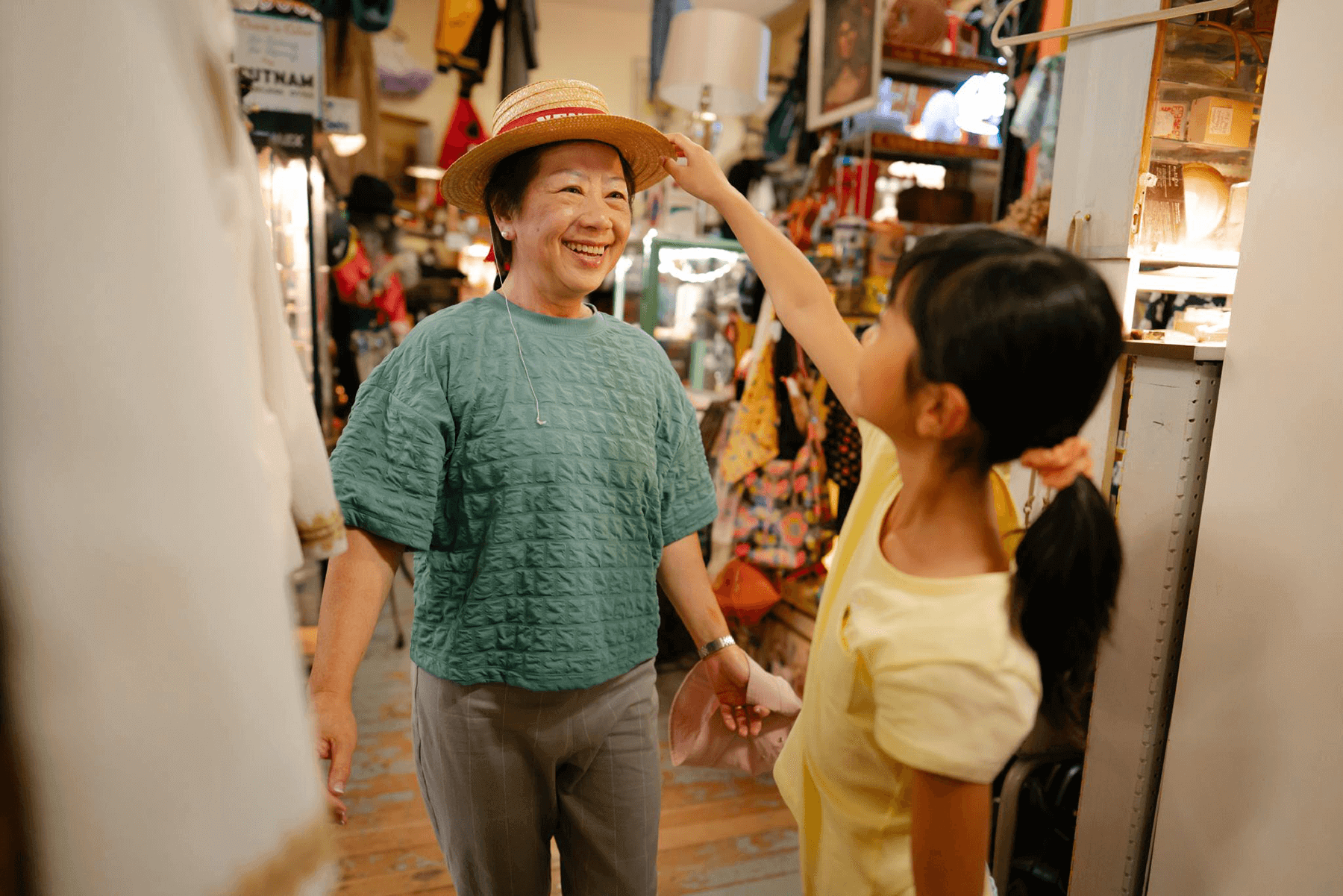 A woman tries on a hat with her granddaughter at Fremont Vintage Mall in Seattle. 