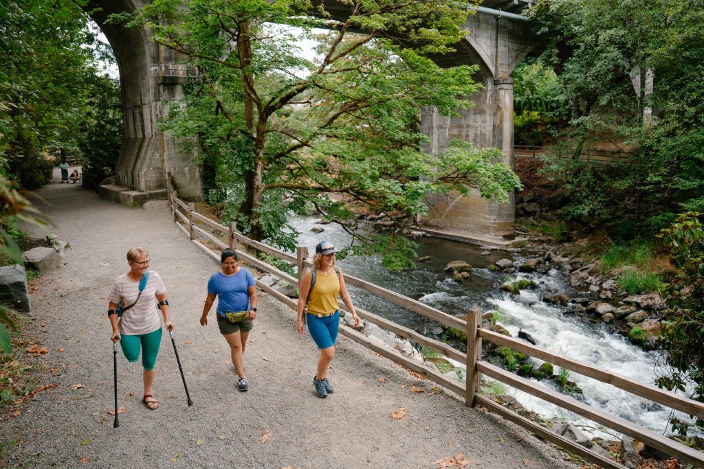 Friends walking along a path in Brewery Park at Tumwater Falls