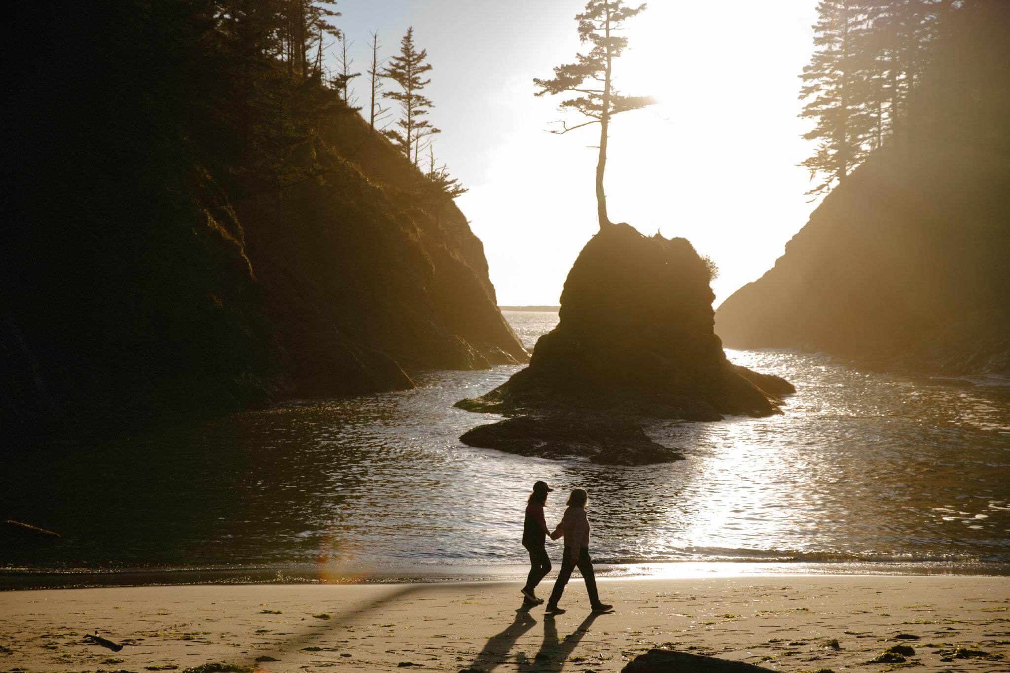 Couple walking the beach at Dead Man's Cove in Cape Disappointment State Park, WA