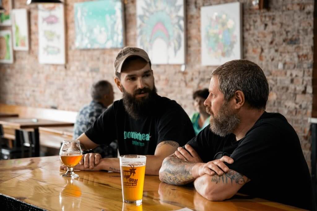 Two men talking over a beer at Iron Goat Brewing Co. in Spokane, WA.