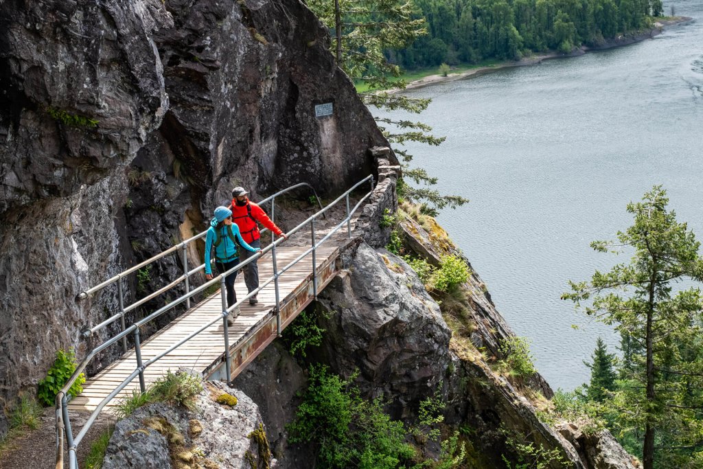 A man and woman walk along a bridge at Beacon Rock State Park, a popular rock climbing destination. 