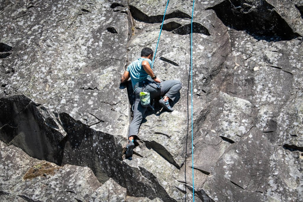 A man scales a rock face.