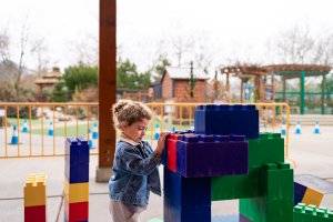 A young girl plays with large legos outside at the Hands On Childrens Museum in Olympia