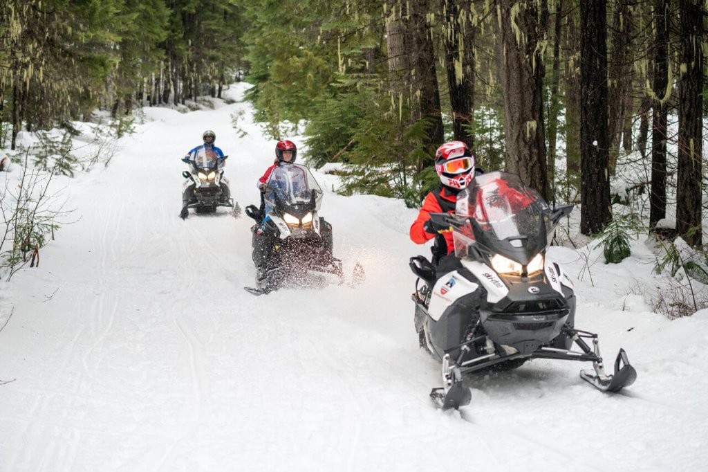 Photo of three adults going snowmobiling in Washington