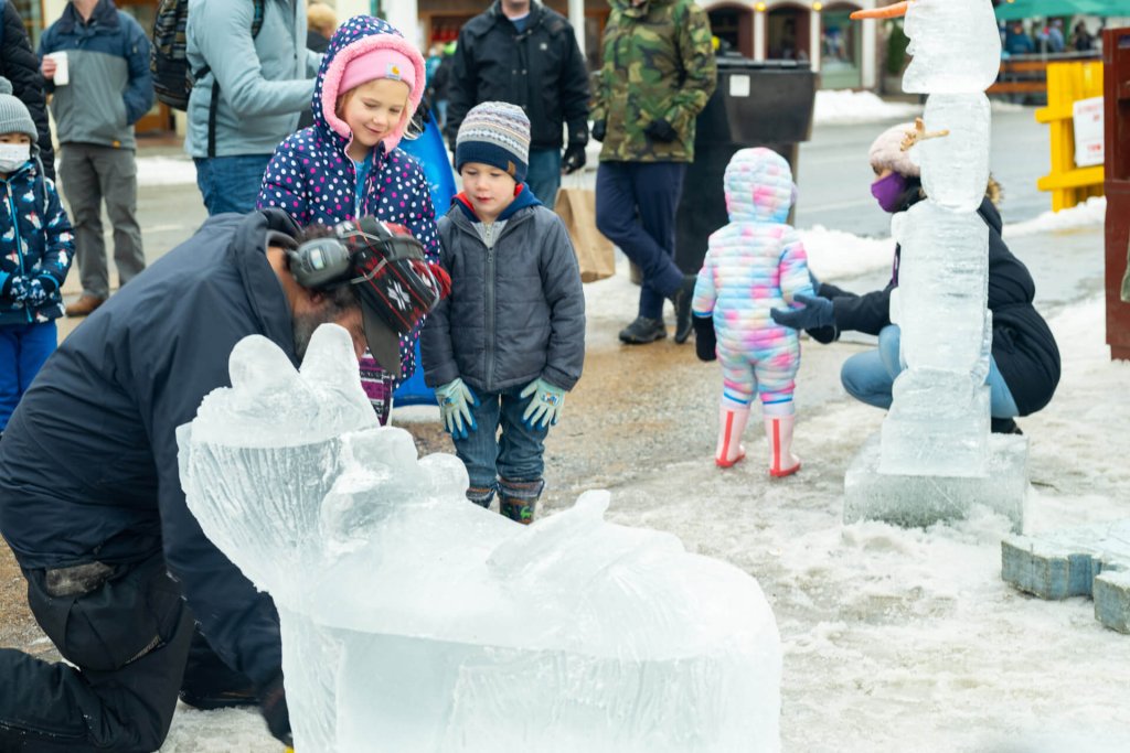 Photo of a man carving an ice sculpture during one of the holiday events in Washington