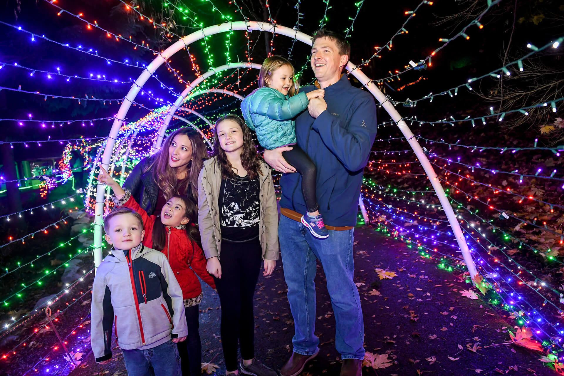 Photo of a family inside a tunnel of Christmas lights during Zoolights, one of many holiday events in Washington