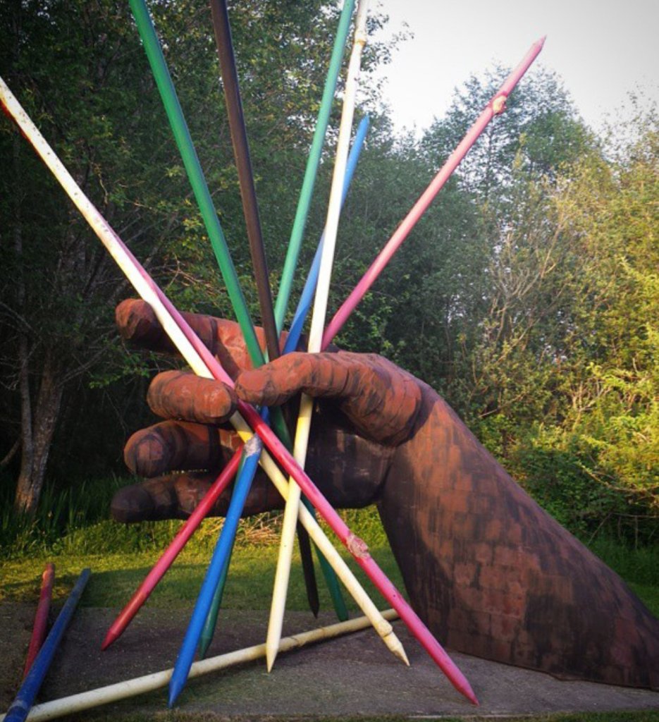 Photo of a sculpture showing a large hand holding colored sticks