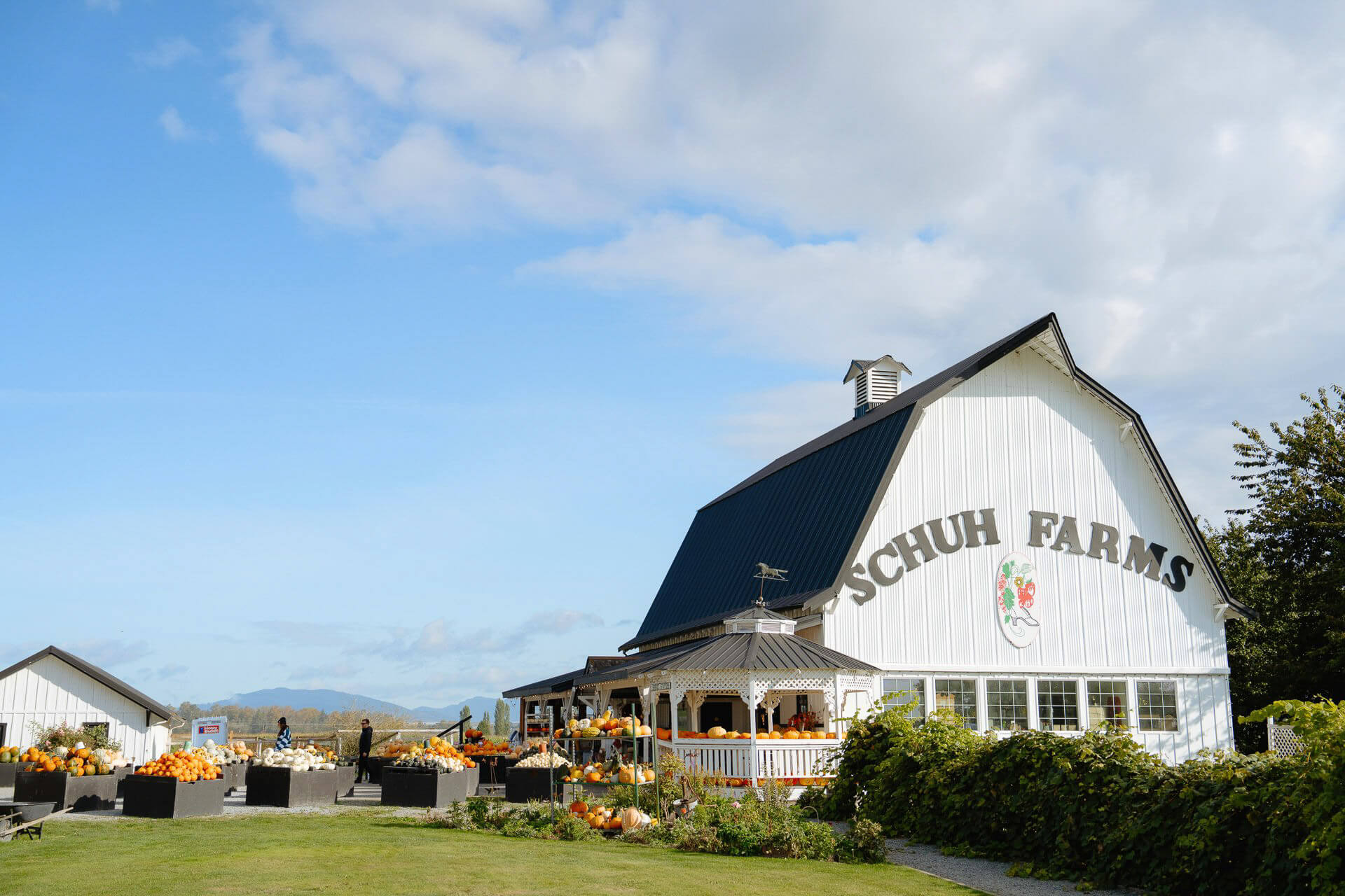 Photo of a white barn with produce out front