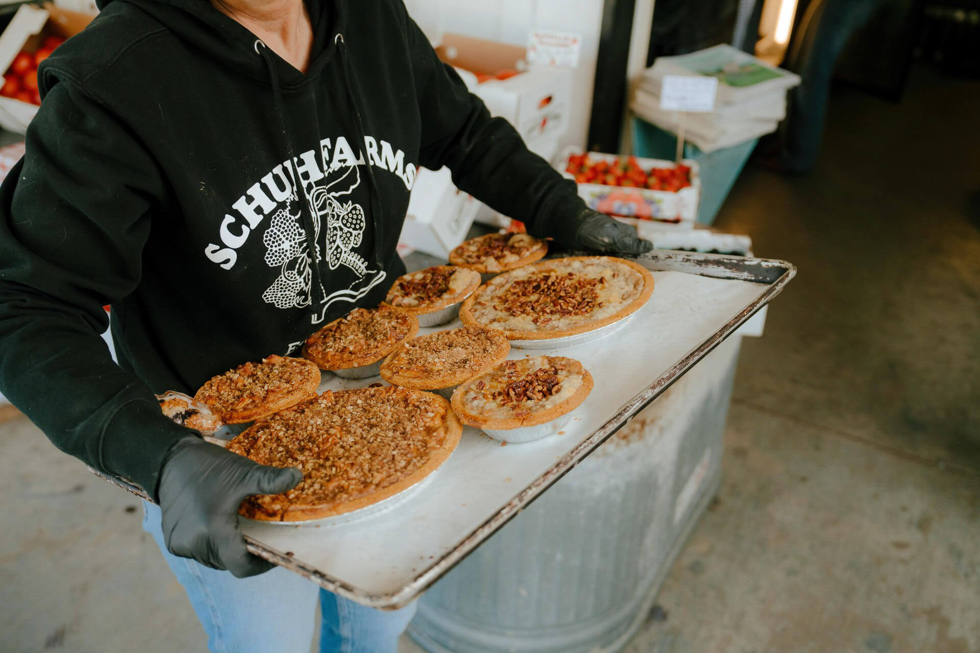 Photo of a person carrying a tray of pies