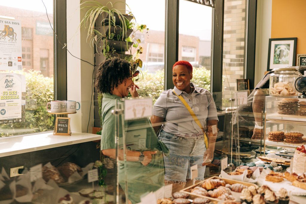 Two women look at baked goods in a bakery