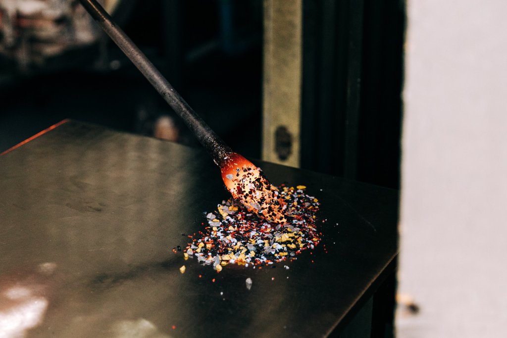 Molton glass is rolled in colorful glass peices