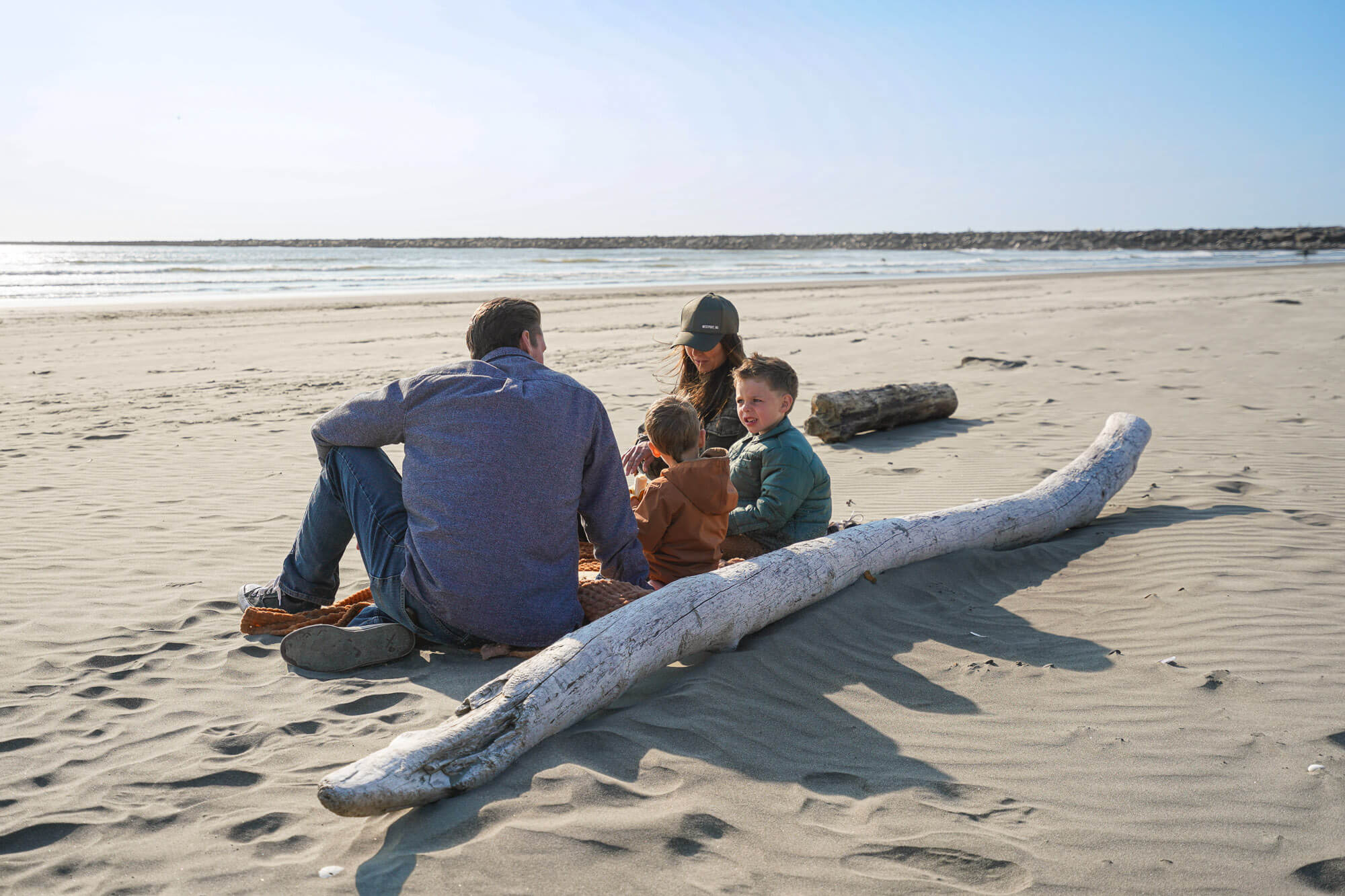 A family sits on a sandy beach in Westport
