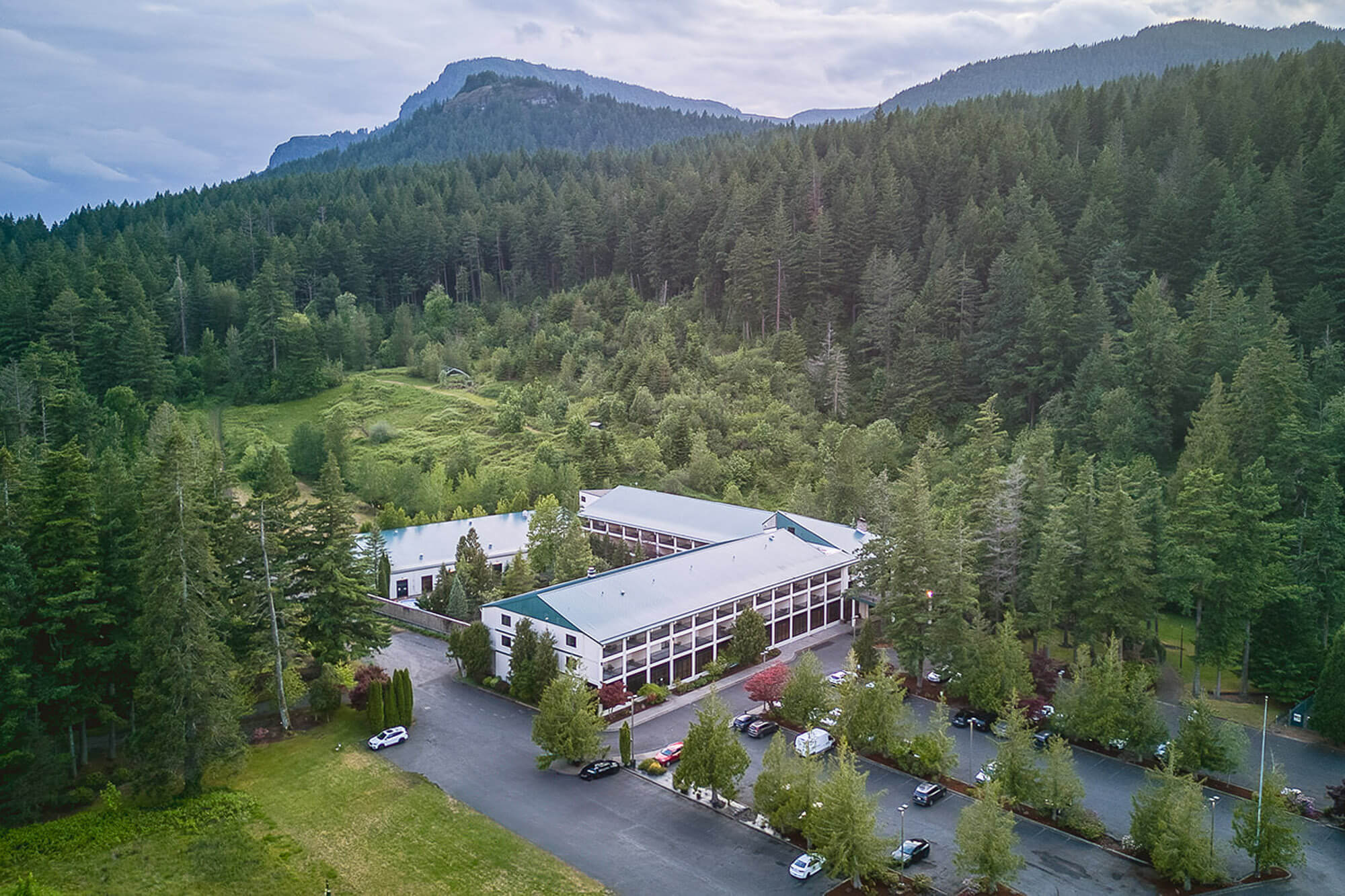 Exterior view of Courtesy of Bonneville Hot Springs Resort & Spa surrounded by forested hills 