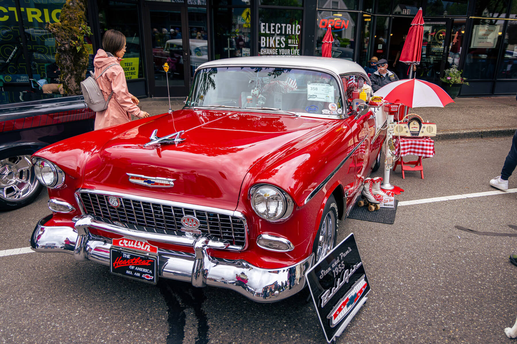 A woman looks at a red vintage auto at a car show in Washington