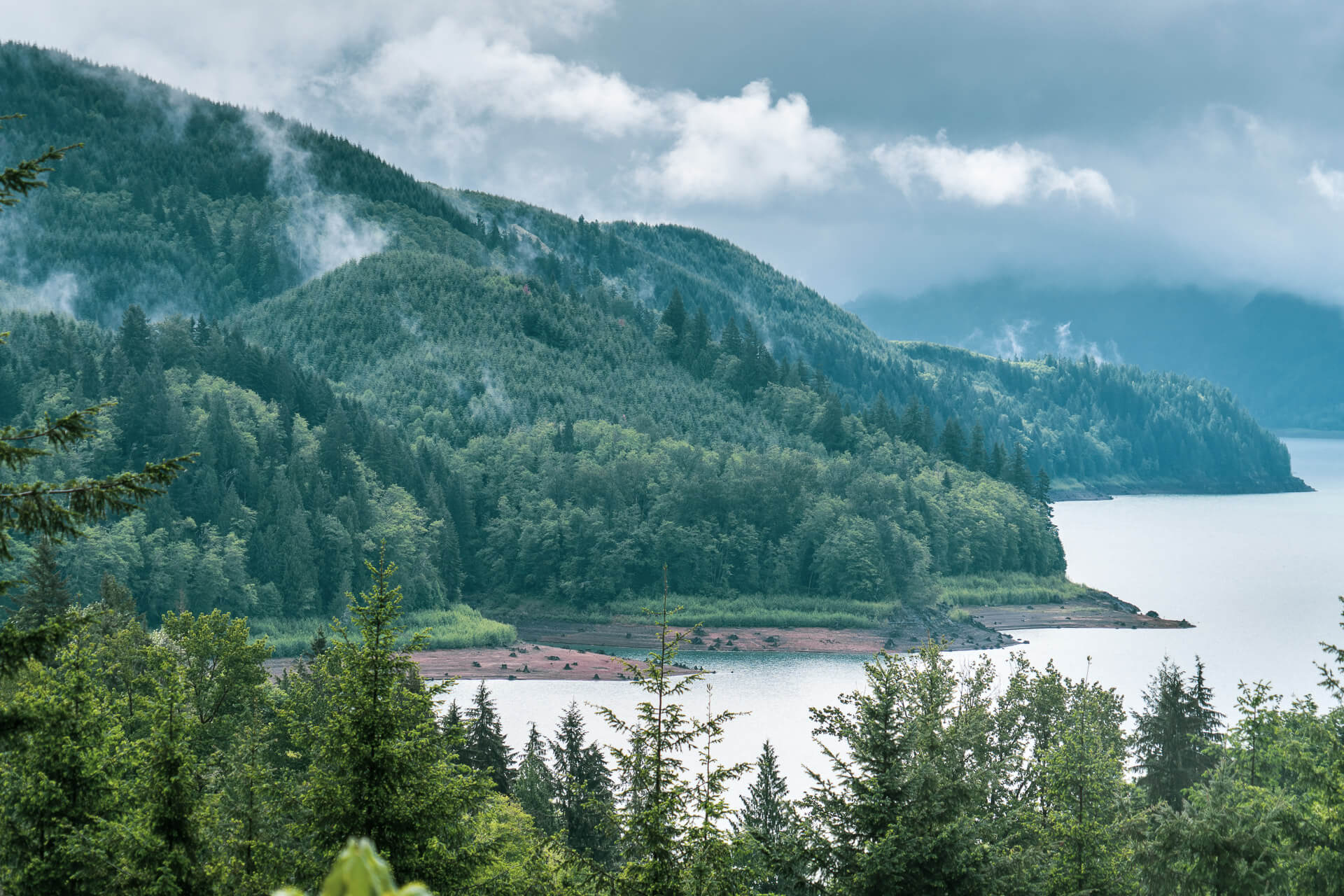 A lake is seen in the distance with tree-covered hills