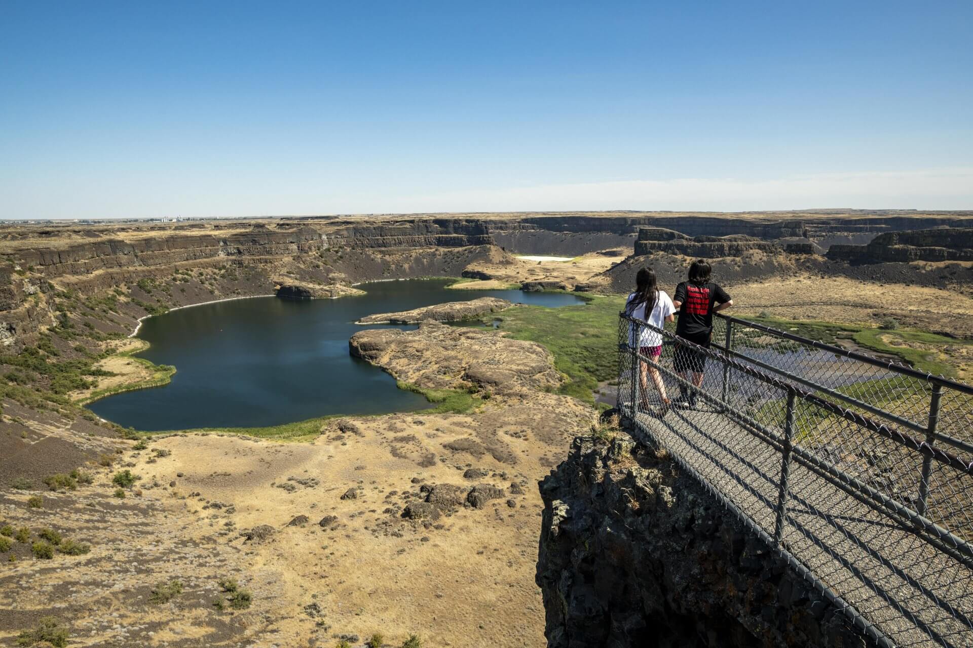 Two people stand at an overlook at Sun Banks-Dry Falls State Park