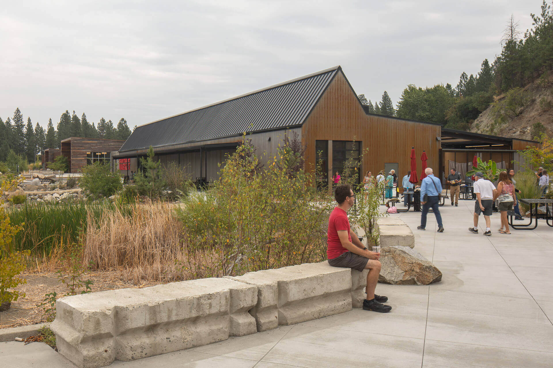 A man sits on a bench outside a building at The Scale House Market